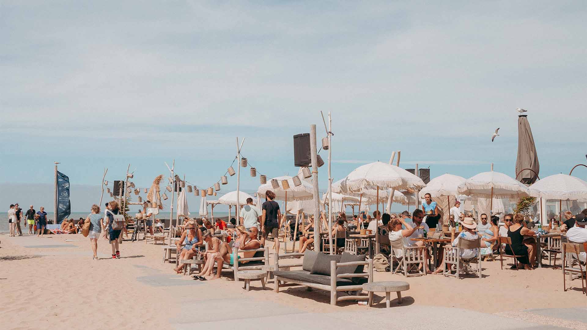 Zijaanzicht van het volle terras in het zand op een zonnige dag