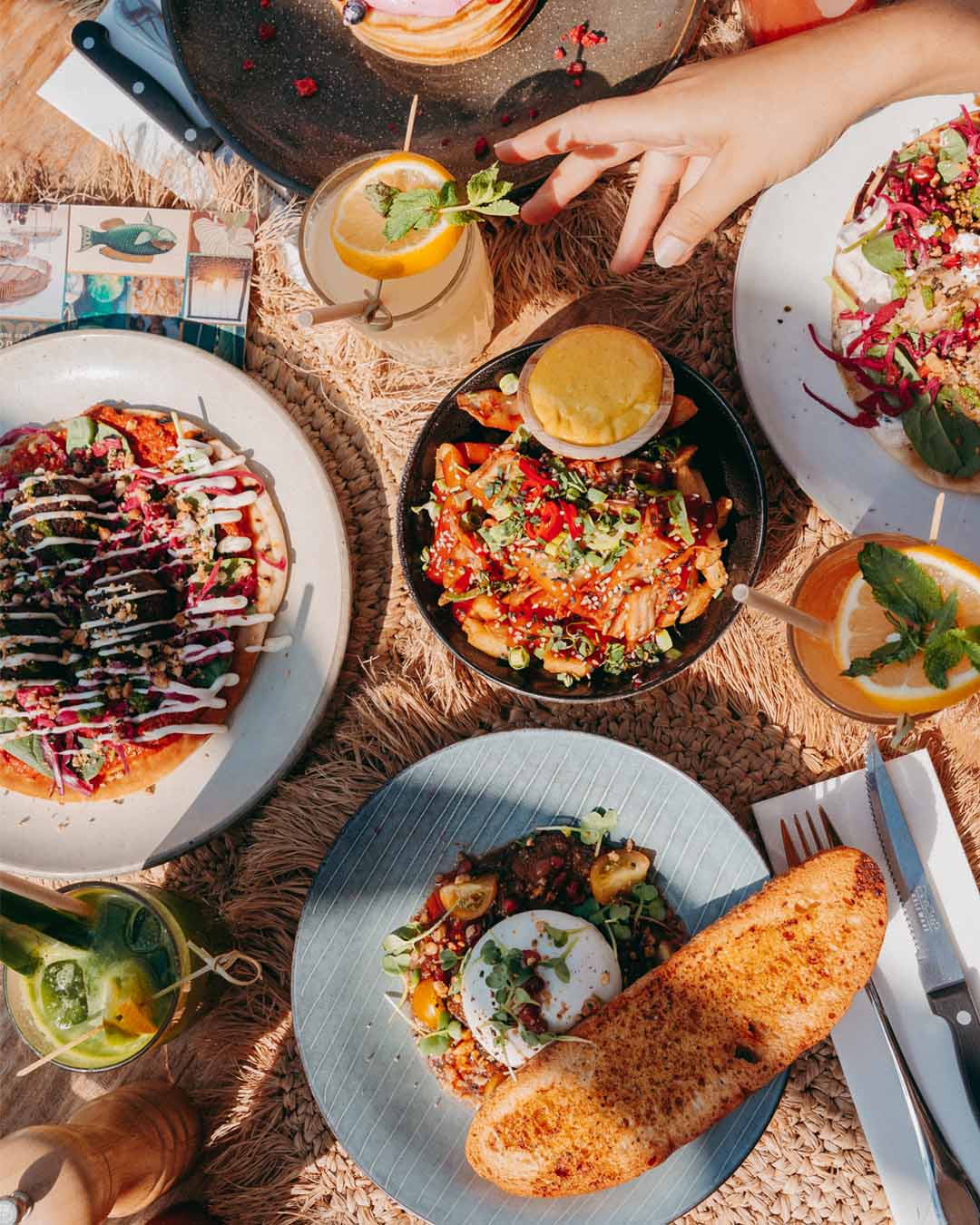 Gedekte tafel van bovenaf met diverse diner-gerechten bij Kayuca Zandvoort