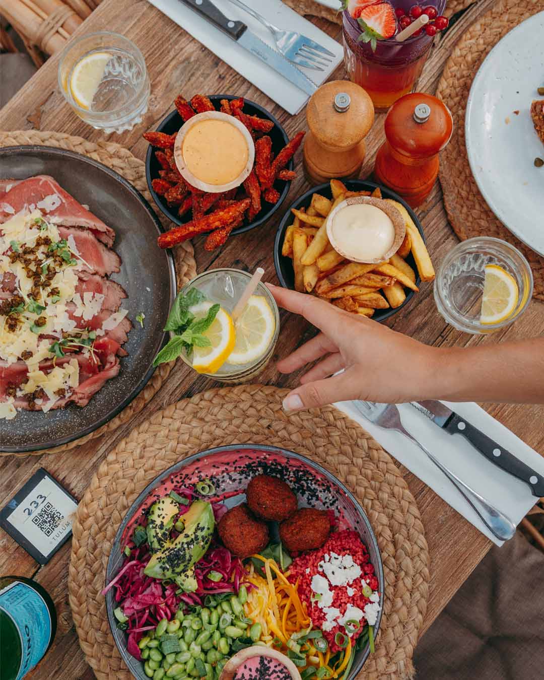 Gedekte tafel van bovenaf met diverse diner-gerechten bij Tulum Noordwijk