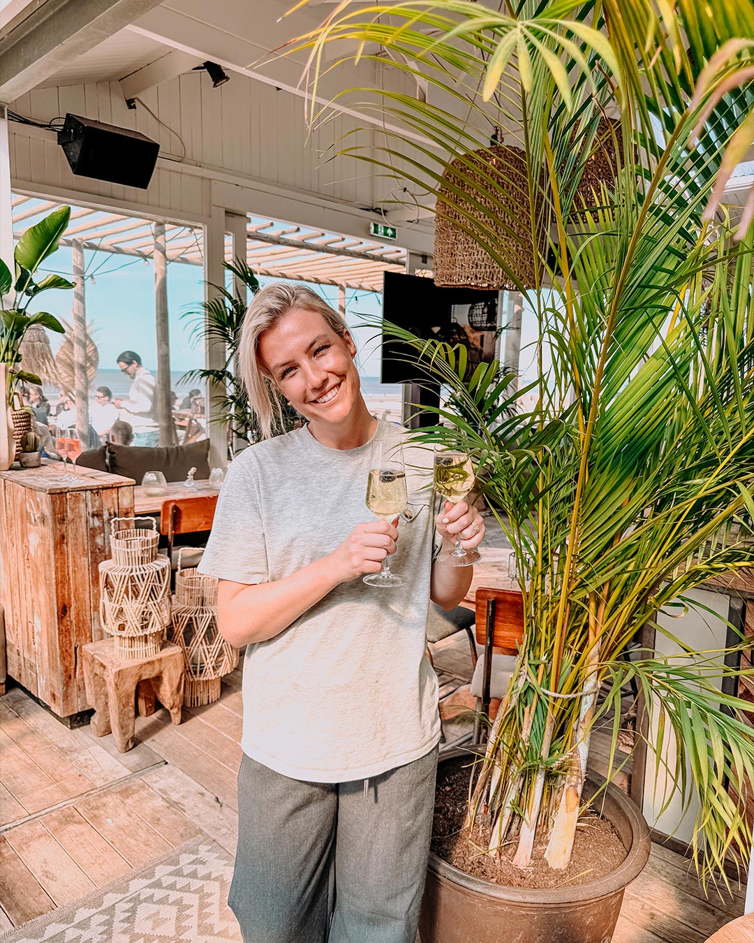 Meisje met twee glazen cava voor groene plant